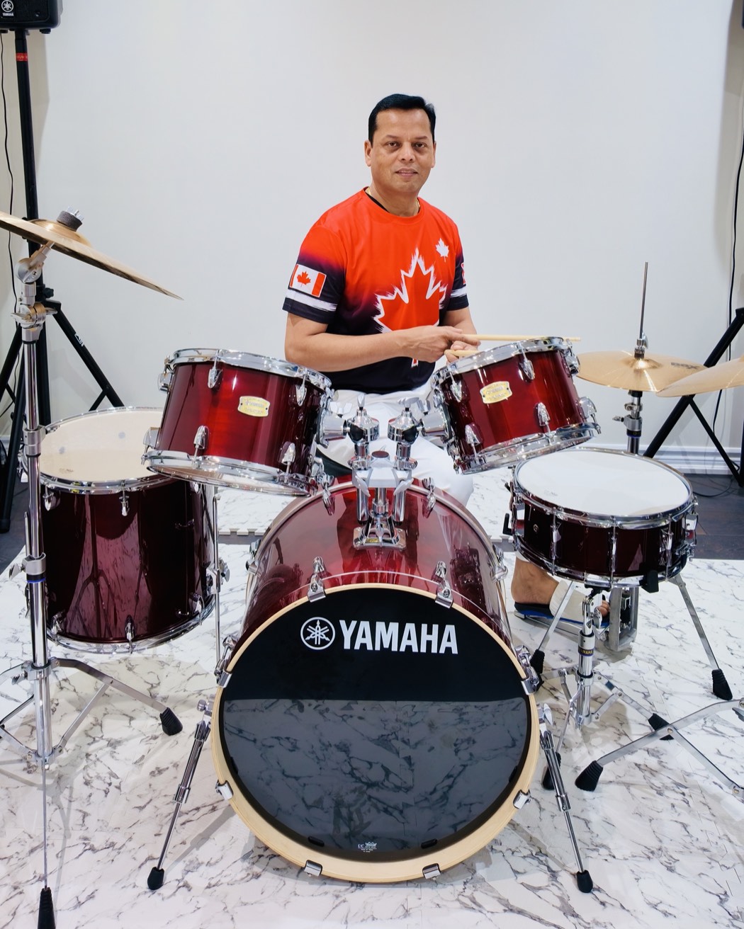 Arvind Choudhary seated at his Yamaha drum kit, sticks in hand.